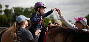 Therapeutic Riding - Therapist working with child on horse